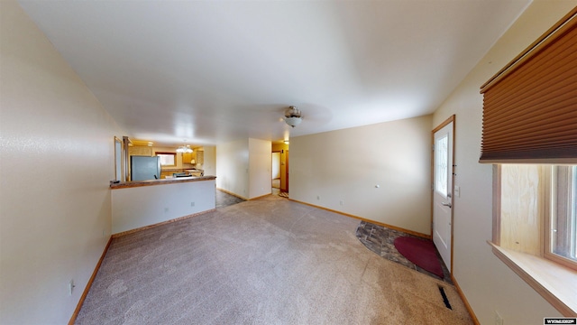 418 Spire Dr, Riverton, WY 82501 - unfurnished living room featuring light colored carpet and baseboards