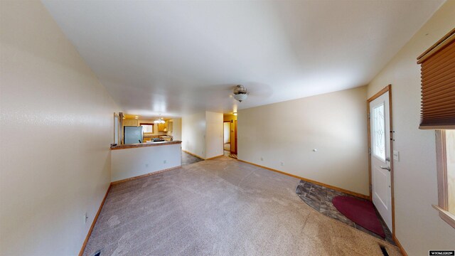 418 Spire Dr, Riverton, WY 82501 - unfurnished living room featuring light carpet and baseboards