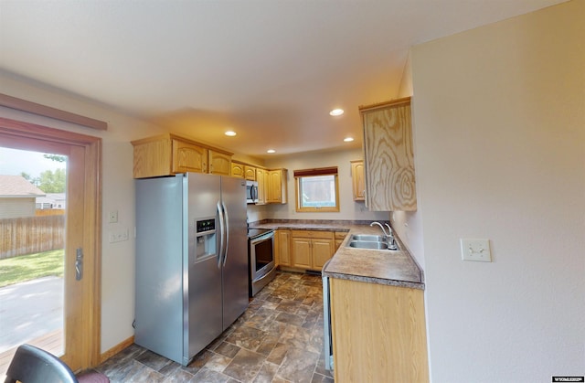 418 Spire Dr, Riverton, WY 82501 - kitchen with appliances with stainless steel finishes, light brown cabinets, stone finish floors, and recessed lighting