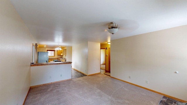 418 Spire Dr, Riverton, WY 82501 - unfurnished living room with baseboards and light colored carpet
