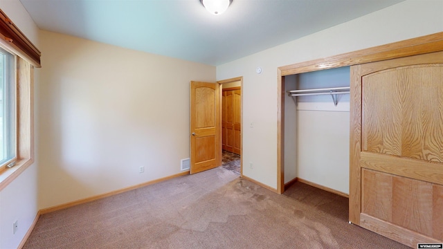 418 Spire Dr, Riverton, WY 82501 - unfurnished bedroom featuring a closet, carpet floors, and multiple windows