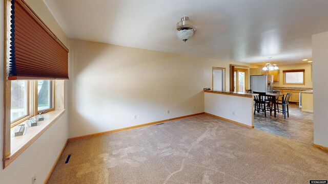 418 Spire Dr, Riverton, WY 82501 - unfurnished living room with carpet and a chandelier
