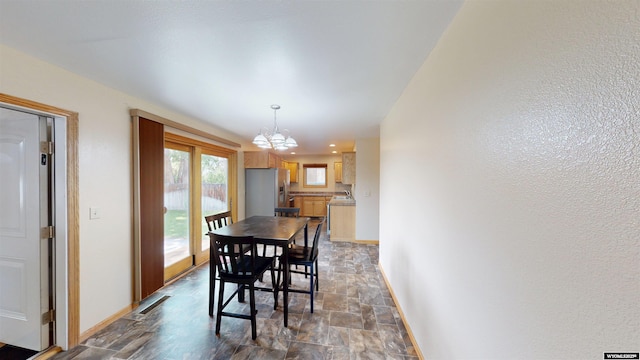 418 Spire Dr, Riverton, WY 82501 - dining room featuring stone finish flooring and a chandelier