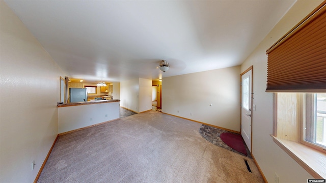 418 Spire Dr, Riverton, WY 82501 - unfurnished living room featuring light colored carpet and baseboards
