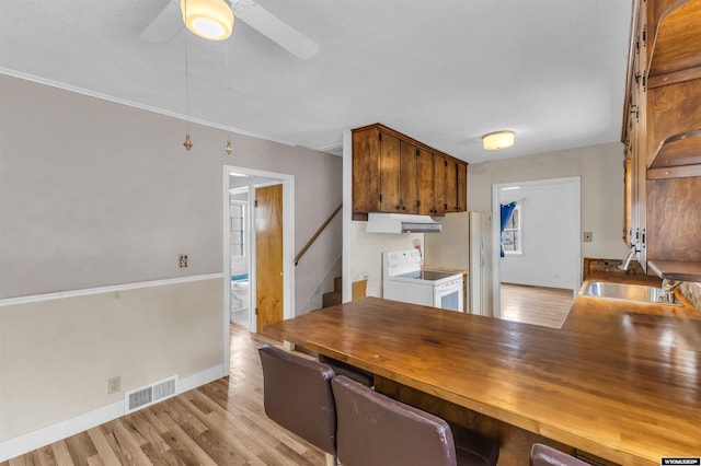 922 New Hampshire St, Rock Springs, WY 82901 - kitchen featuring white appliances, under cabinet range hood, light wood-type flooring, ceiling fan, and wooden counters