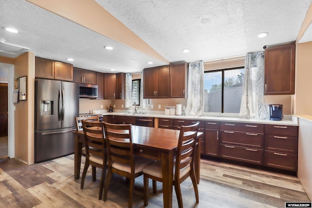 301 Cottonwood St, Evanston, WY 82930 - kitchen with appliances with stainless steel finishes, a textured ceiling, light countertops, healthy amount of natural light, and light wood-style flooring