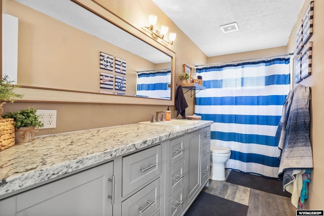 301 Cottonwood St, Evanston, WY 82930 - bathroom featuring vanity, wood finished floors, a textured ceiling, and a shower with shower curtain