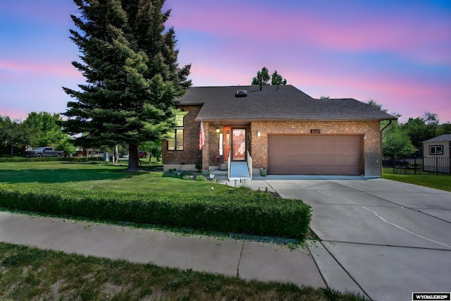 606 Herschler Ave, Evanston, WY 82930 - view of front facade with concrete driveway, a garage, and brick siding
