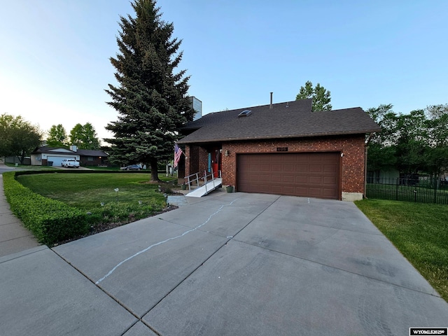 606 Herschler Ave, Evanston, WY 82930 - view of front of home with brick siding, concrete driveway, an attached garage, and roof with shingles