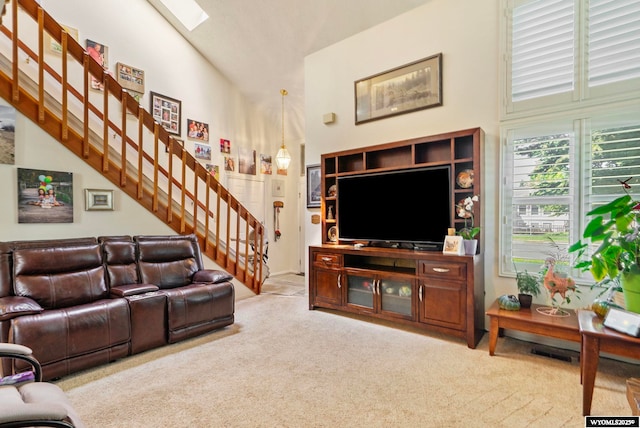 606 Herschler Ave, Evanston, WY 82930 - carpeted living room with stairway, a high ceiling, and a skylight