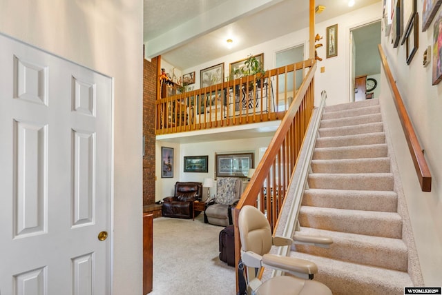 606 Herschler Ave, Evanston, WY 82930 - staircase featuring a towering ceiling, carpet flooring, and beamed ceiling