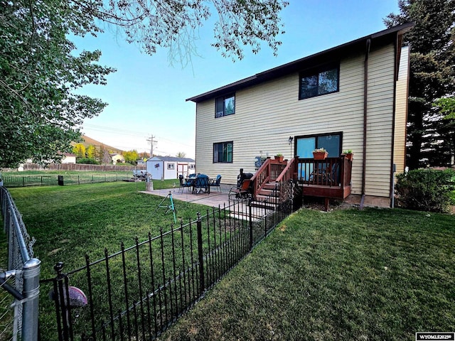 606 Herschler Ave, Evanston, WY 82930 - back of property with a fenced backyard, a deck, a storage unit, and a patio area