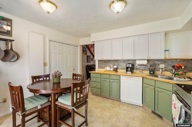 606 Herschler Ave, Evanston, WY 82930 - kitchen with white dishwasher, green cabinets, stainless steel range with electric stovetop, and decorative backsplash