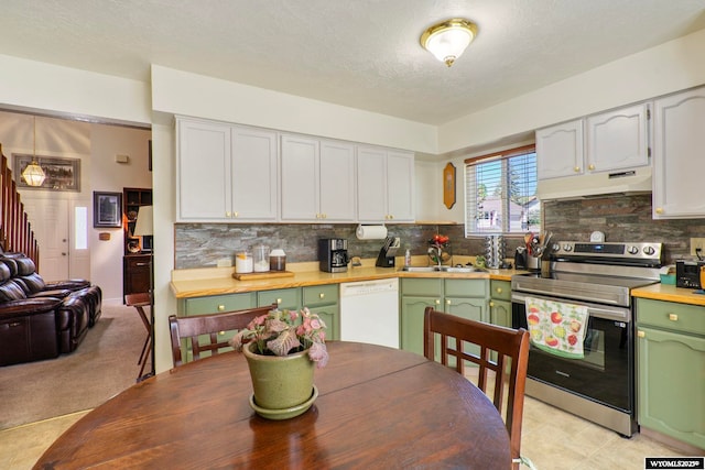 606 Herschler Ave, Evanston, WY 82930 - kitchen with stainless steel electric range oven, white dishwasher, under cabinet range hood, green cabinets, and decorative backsplash