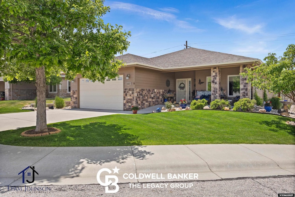 840 Recluse Ct, Casper, WY 82609 - view of front of house featuring concrete driveway, stone siding, an attached garage, and a front yard