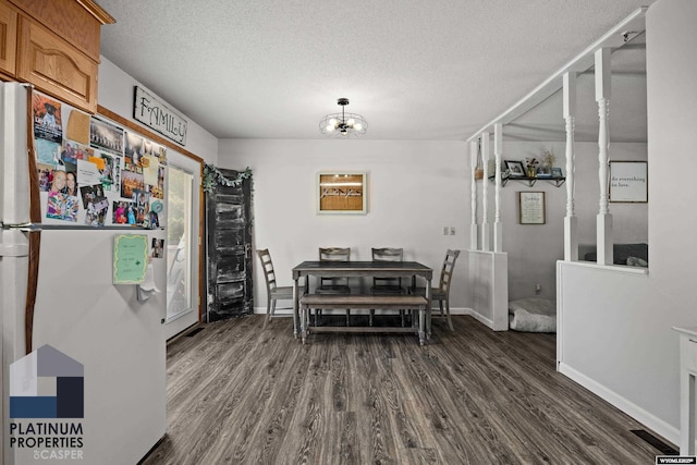 3440 E 18th St, Casper, WY 82609 - dining space featuring dark wood finished floors, a textured ceiling, and a chandelier