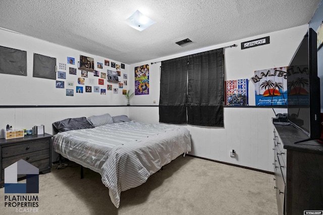 3440 E 18th St, Casper, WY 82609 - bedroom featuring a textured ceiling, a wainscoted wall, and light colored carpet