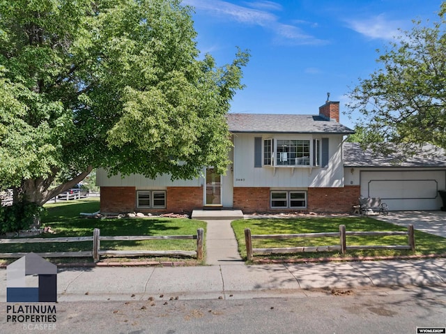 3440 E 18th St, Casper, WY 82609 - view of front of property featuring a fenced front yard, a chimney, a garage, driveway, and brick siding