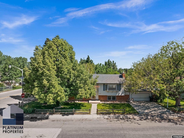 3440 E 18th St, Casper, WY 82609 - view of front facade with brick siding, driveway, a chimney, and a garage