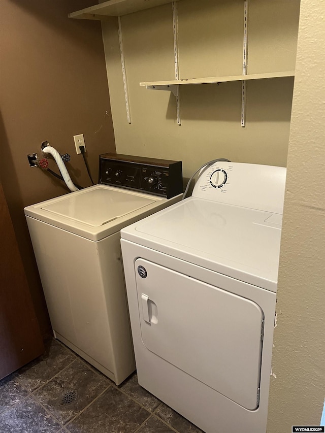 6358 Buckboard Rd, Casper, WY 82604 - laundry room with separate washer and dryer and dark stone finish floors