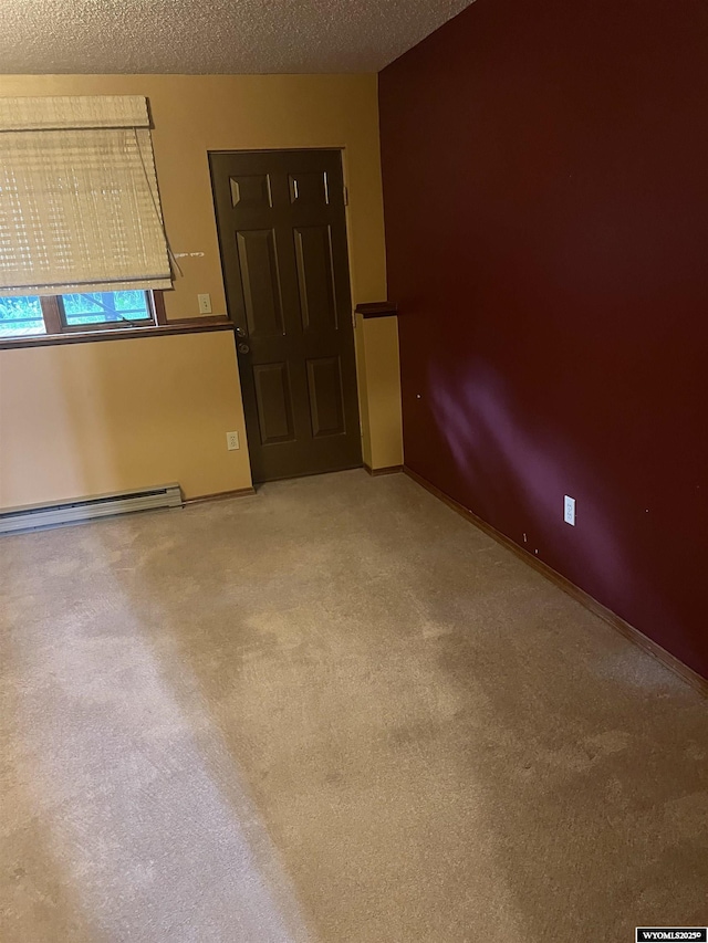6358 Buckboard Rd, Casper, WY 82604 - spare room featuring a baseboard heating unit, carpet flooring, and a textured ceiling