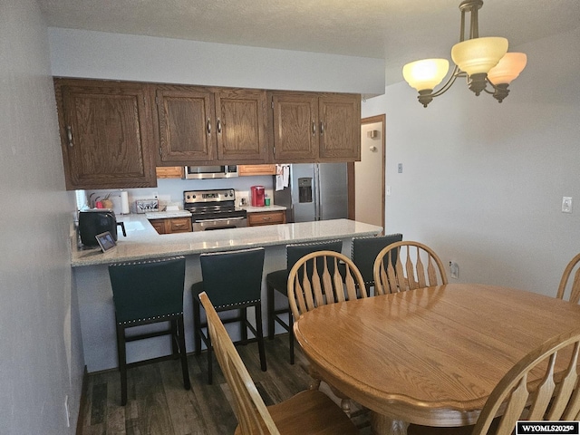 1150 Park View Dr, Green River, WY 82935 - kitchen featuring appliances with stainless steel finishes, light countertops, wood finished floors, and a peninsula