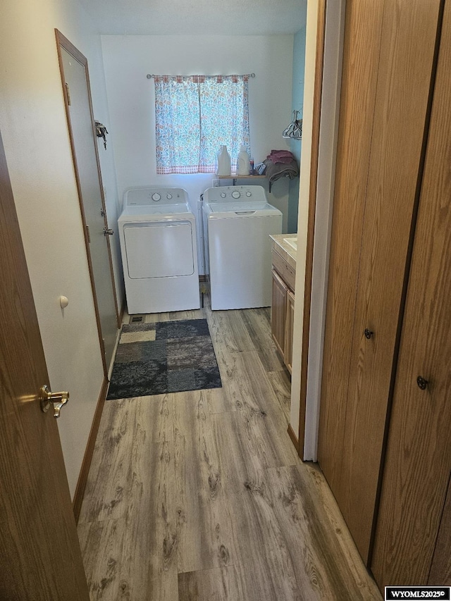 1150 Park View Dr, Green River, WY 82935 - laundry area featuring cabinet space, washer and clothes dryer, and light wood finished floors