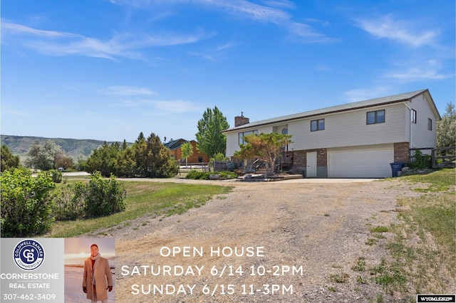 4450 S Skyline Rd, Casper, WY 82604 - view of front of house with an attached garage, dirt driveway, brick siding, and a chimney