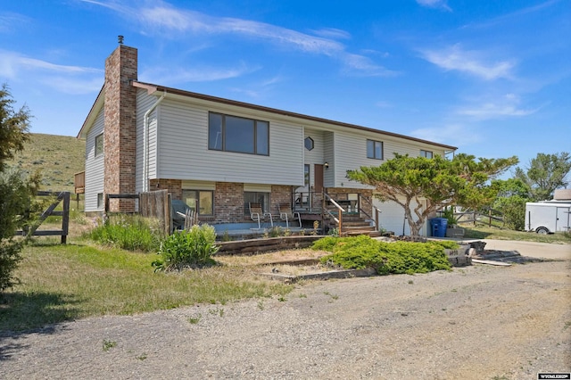 4450 S Skyline Rd, Casper, WY 82604 - bi-level home featuring a chimney, a garage, brick siding, and driveway