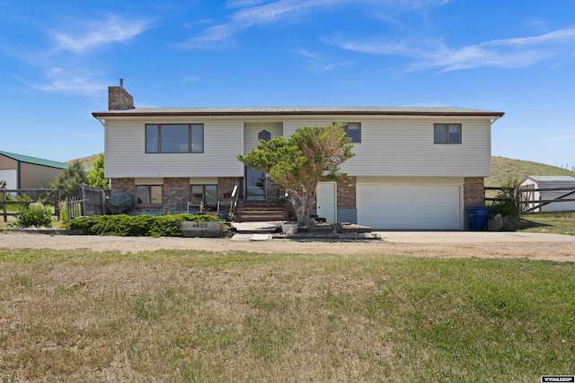 4450 S Skyline Rd, Casper, WY 82604 - raised ranch featuring brick siding, a chimney, an attached garage, and driveway
