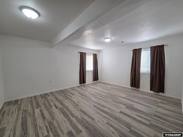 7866 Scorpion Way, Evansville, WY 82636 - empty room featuring wood finished floors and beam ceiling