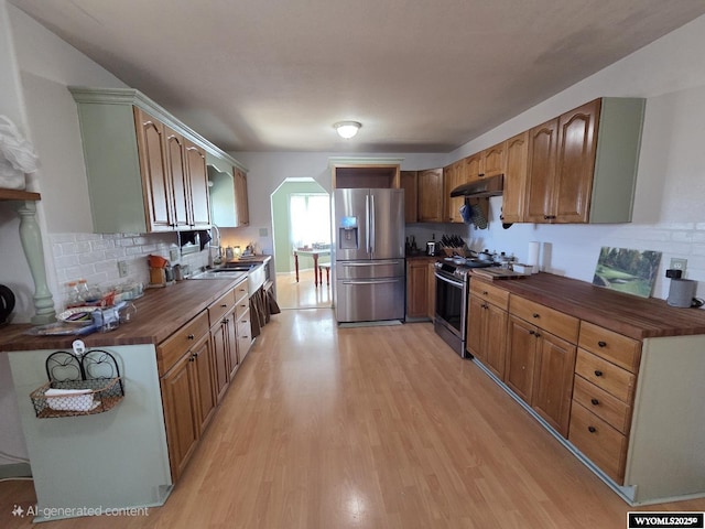 7866 Scorpion Way, Evansville, WY 82636 - kitchen with appliances with stainless steel finishes, under cabinet range hood, butcher block counters, light wood-style floors, and backsplash