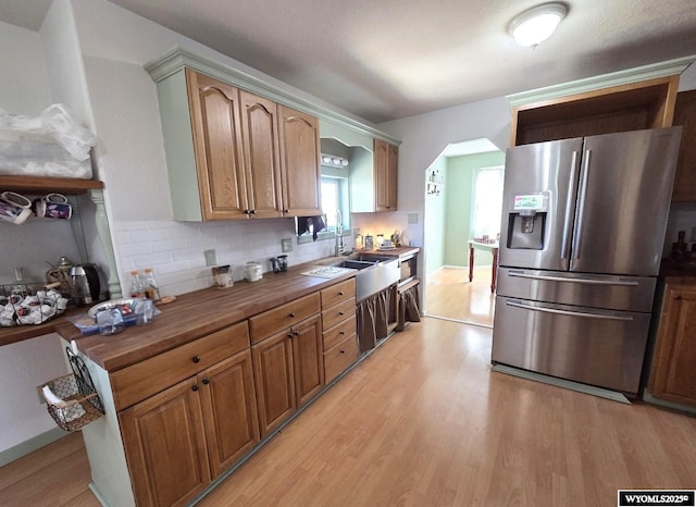 7866 Scorpion Way, Evansville, WY 82636 - kitchen with stainless steel refrigerator with ice dispenser, light wood finished floors, wooden counters, and backsplash