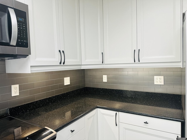 829 Belinda Dr, Riverton, WY 82520 - kitchen with stainless steel microwave, white cabinets, decorative backsplash, dark stone countertops, and range with electric stovetop