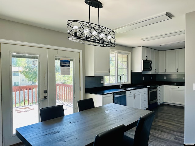 829 Belinda Dr, Riverton, WY 82520 - kitchen featuring stainless steel appliances, a chandelier, white cabinets, dark countertops, and backsplash