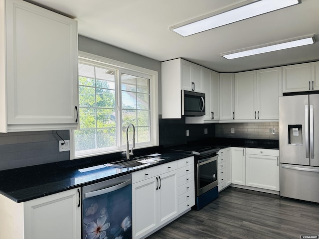 829 Belinda Dr, Riverton, WY 82520 - kitchen with stainless steel appliances, white cabinetry, dark countertops, and backsplash