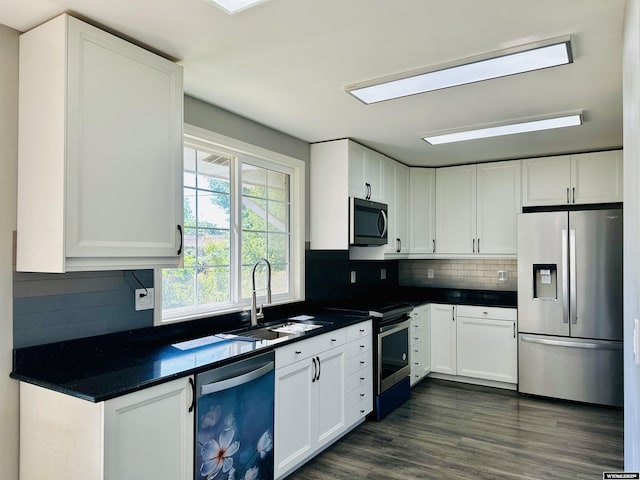 829 Belinda Dr, Riverton, WY 82520 - kitchen with appliances with stainless steel finishes, dark countertops, white cabinetry, and backsplash