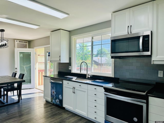 829 Belinda Dr, Riverton, WY 82520 - kitchen with appliances with stainless steel finishes, dark countertops, decorative backsplash, dark wood-type flooring, and white cabinetry