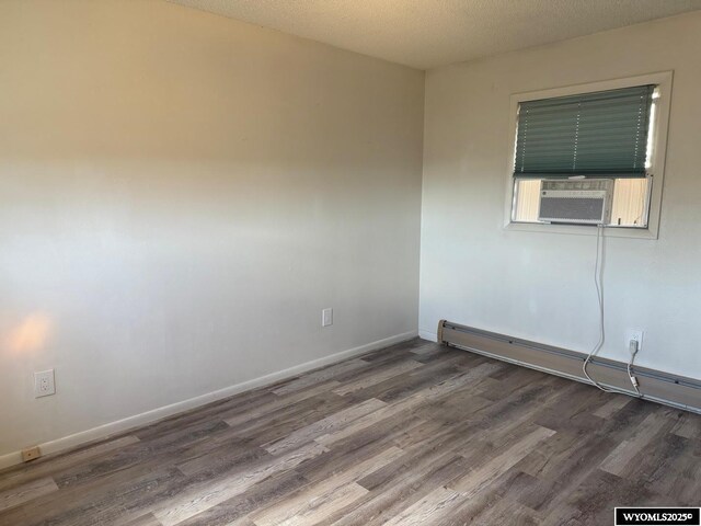 1630 Coulson Dr, Rawlins, WY 82301 - unfurnished room with a baseboard heating unit, wood finished floors, cooling unit, and a textured ceiling