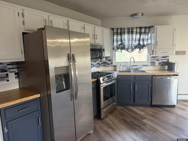1630 Coulson Dr, Rawlins, WY 82301 - kitchen with appliances with stainless steel finishes, white cabinets, a textured ceiling, and tasteful backsplash
