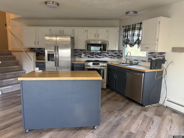 1630 Coulson Dr, Rawlins, WY 82301 - kitchen featuring stainless steel appliances, butcher block countertops, decorative backsplash, dark wood-style flooring, and a textured ceiling