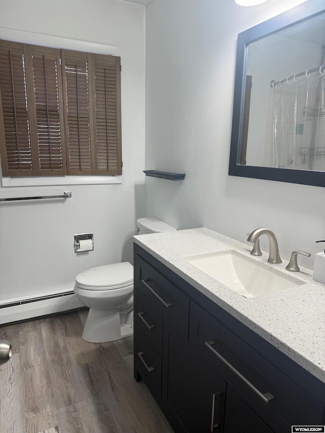 1630 Coulson Dr, Rawlins, WY 82301 - full bath with a baseboard heating unit, vanity, wood finished floors, and curtained shower