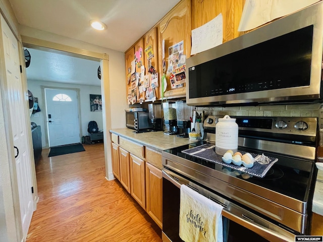 1328 Canyon Ct, Kemmerer, WY 83101 - kitchen featuring stainless steel appliances, backsplash, light countertops, light wood-type flooring, and brown cabinets