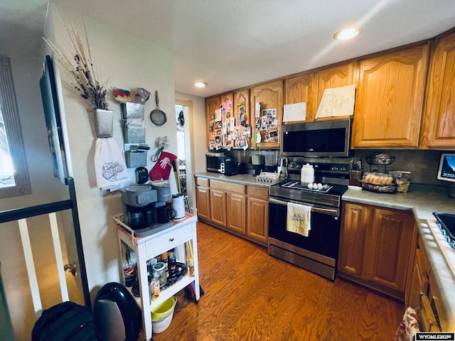 1328 Canyon Ct, Kemmerer, WY 83101 - kitchen with stainless steel appliances, light countertops, light wood-style floors, brown cabinets, and recessed lighting