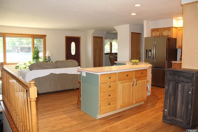 1540 Manor Dr, Casper, WY 82609 - kitchen featuring stainless steel fridge with ice dispenser, light countertops, light wood-style flooring, a center island, and plenty of natural light