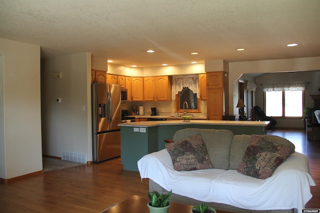 1540 Manor Dr, Casper, WY 82609 - kitchen featuring appliances with stainless steel finishes, a textured ceiling, dark wood-style flooring, light countertops, and recessed lighting