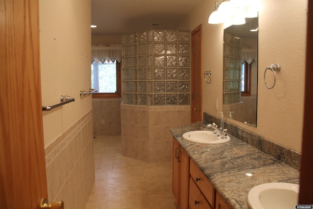 1540 Manor Dr, Casper, WY 82609 - full bathroom featuring double vanity, tile patterned floors, walk in shower, and tile walls