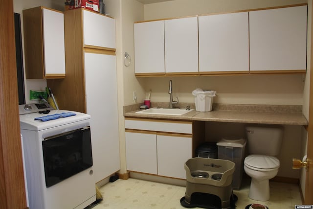 1540 Manor Dr, Casper, WY 82609 - kitchen with washer / dryer, light countertops, light flooring, and white cabinets