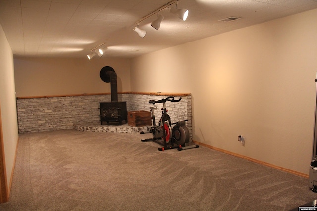 1540 Manor Dr, Casper, WY 82609 - basement with track lighting, carpet, a wood stove, and brick wall