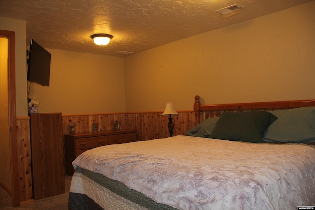 1540 Manor Dr, Casper, WY 82609 - bedroom with a wainscoted wall, a textured ceiling, and wood walls